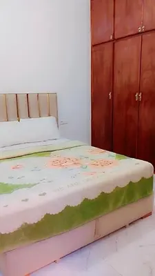 a bed sitting in a bedroom with a wooden cabinet at Kawtar in Marrakech