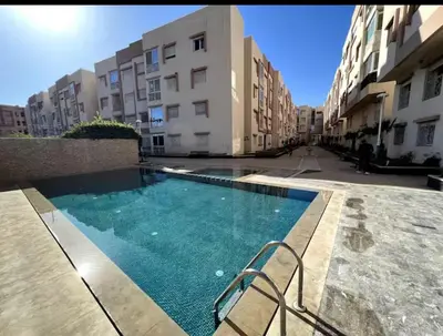 a swimming pool in the middle of a building at Appartement neuf & moderne avec clim, piscine & balcon,Proche Jemaa el-Fna & Guéliz in Marrakech