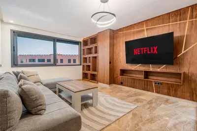 a living room with a couch and a tv at 1 Ch, 1 SDB et Parking gratuit au Centre de Gueliz avec vue in Marrakech