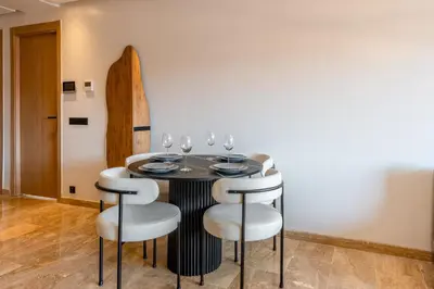 a dining room with a table with chairs and wine glasses at 1 Ch, 1 SDB et Parking gratuit au Centre de Gueliz avec vue in Marrakech