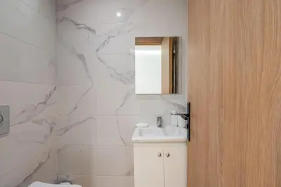 a white bathroom with a sink and a mirror at 1 Ch, 1 SDB et Parking gratuit au Centre de Gueliz avec vue in Marrakech