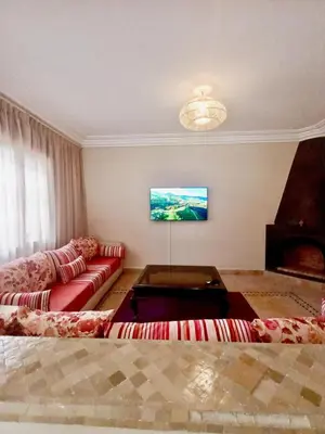 a living room with a red couch and a tv at charming mini villa in Marrakech