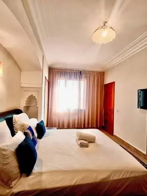 a bedroom with a large white bed with a window at charming mini villa in Marrakech