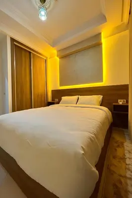a large white bed in a room with yellow walls at Appartement cosy à 8 min de RAK à pied in Marrakech