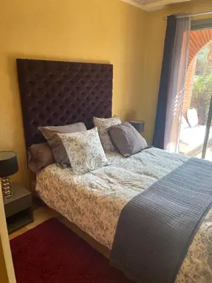 a bedroom with a bed with pillows and a window at Appartement les jardins de la Palmeraie III in Marrakech
