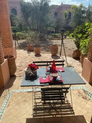 a table on a patio with flowers on it at Appartement les jardins de la Palmeraie III in Marrakech