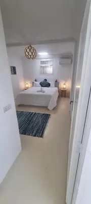 a white bedroom with a bed and a window at VILLA Malaika in Marrakech