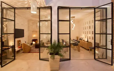 a living room with a large glass wall at Riad la Source du Desert in Marrakech