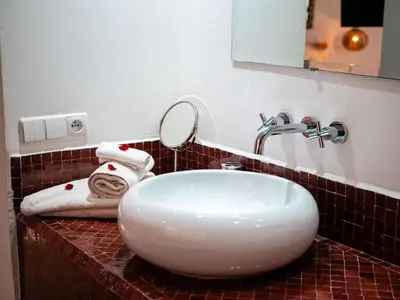 a bathroom with a white sink and a mirror at Riad la Source du Desert in Marrakech