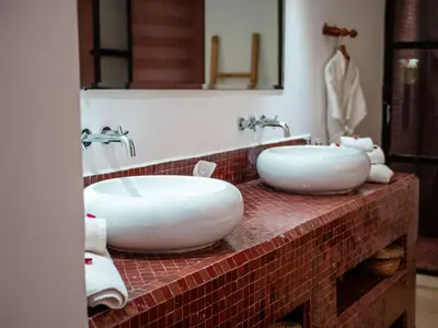 a bathroom with two white sinks on a brick counter at Riad la Source du Desert in Marrakech