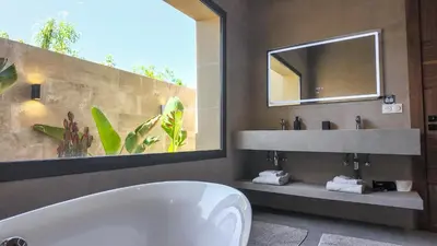 a bathroom with a tub and a sink and a mirror at Villa SLIMANE - Villa plain-pied sans vis à vis in Marrakech