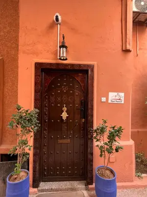 a wooden door with two potted plants in front of it at Riad Mounaf in Marrakech