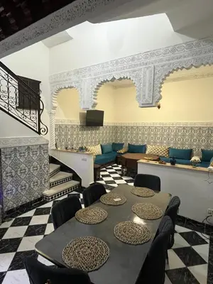 a room with a table and chairs and a checkered floor at Riad Mounaf in Marrakech
