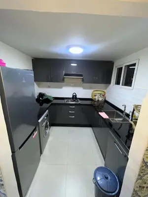 a small kitchen with black cabinets and a sink at Riad Mounaf in Marrakech