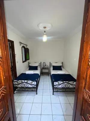 a room with two beds in a room at Riad Mounaf in Marrakech