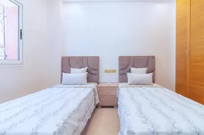 two beds sitting next to each other in a room at Appart VIP 5 étoiles et romantique à Guéliz avec Piscine, Clim, Parking et Wifi haut débit 200 Mb in Marrakech