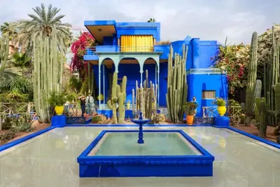 a blue building with a fountain in the middle of a pool at Appart VIP 5 étoiles et romantique à Guéliz avec Piscine, Clim, Parking et Wifi haut débit 200 Mb in Marrakech