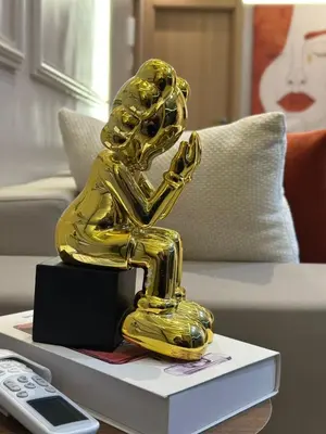 a gold statue of a man on a table at Homekesh in Marrakech