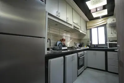 a kitchen with white cabinets and a refrigerator at Dar lalla in Marrakech