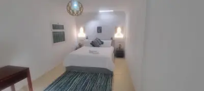 a white bedroom with a bed and a rug at Villa NAIM in Marrakech