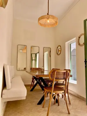 a dining room with a table and chairs and mirrors at Riad Nouonsa 4ch 8 pax Medina Bab Taghzout in Marrakech