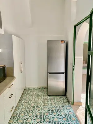 a kitchen with a stainless steel refrigerator on a tile floor at Riad Nouonsa 4ch 8 pax Medina Bab Taghzout in Marrakech
