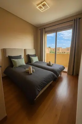 a bedroom with a large bed with a large window at Appartement prestigia Marrakech in Marrakech