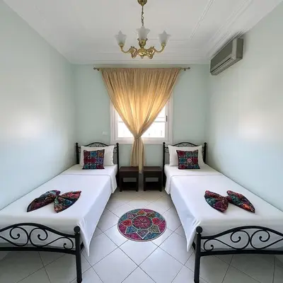 two beds in a room with a window at NF15 by Majestic Properties in Marrakech