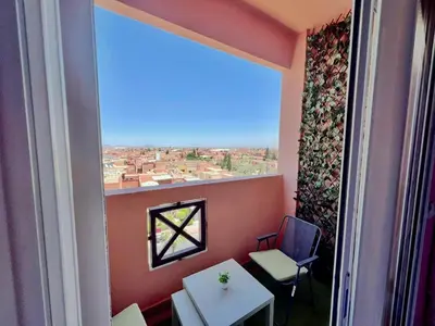 a room with a window with a table and chairs at NF15 by Majestic Properties in Marrakech