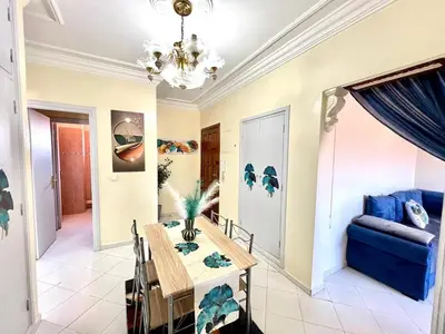 a dining room with a table and a blue couch at NF15 by Majestic Properties in Marrakech