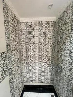 a bathroom with a tiled wall with a shower at Riad Maaffar in Marrakech