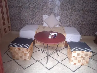 a room with a bed with a table and two chairs at Riad Maaffar in Marrakech