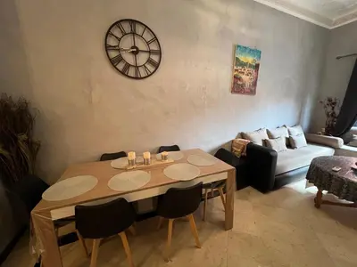a living room with a table and a clock on the wall at Apartment NE 4 by Majestic Properties in Marrakech