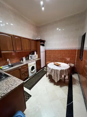 a kitchen with a table and a white refrigerator at Apartment NE 4 by Majestic Properties in Marrakech