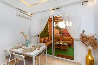 a white dining room with a white table and chairs at Au cœur du centre ville Gueliz a coté de Carre Eden et Plaza in Marrakech