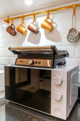 a microwave oven with pots and pans on a wall at Au cœur du centre ville Gueliz a coté de Carre Eden et Plaza in Marrakech