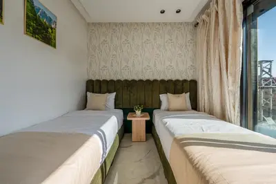 two beds in a room with a window at The Marrakech Mosaic A Fusion of Style city Central in Marrakech