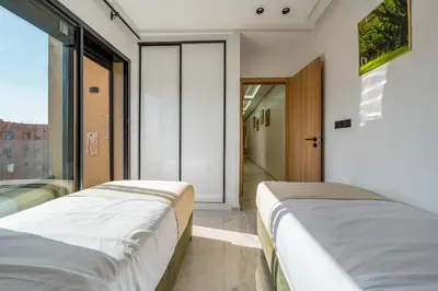 two beds in a room with a window at The Marrakech Mosaic A Fusion of Style city Central in Marrakech