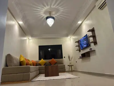 a living room with a couch and a tv at Appartement familière luxe hay menara in Marrakech