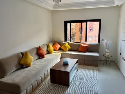 a living room with a couch with colorful pillows at Appartement familière luxe hay menara in Marrakech
