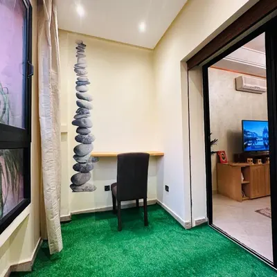 a room with a chair and a table and a mirror at Chic stay near Gueliz - Free parking in Marrakech