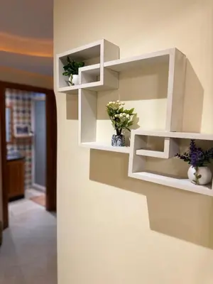 a room with white shelves on a wall with flowers at Chic stay near Gueliz - Free parking in Marrakech