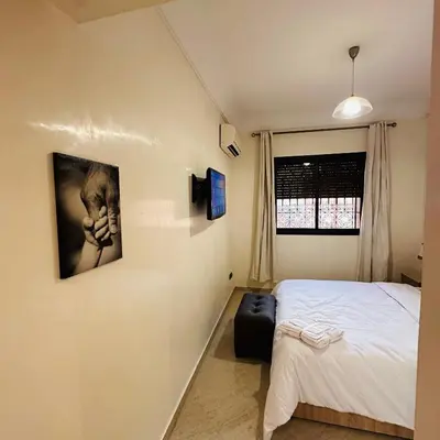 a bedroom with a bed and a picture on the wall at Chic stay near Gueliz - Free parking in Marrakech