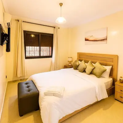 a bedroom with a large white bed and a window at Chic stay near Gueliz - Free parking in Marrakech