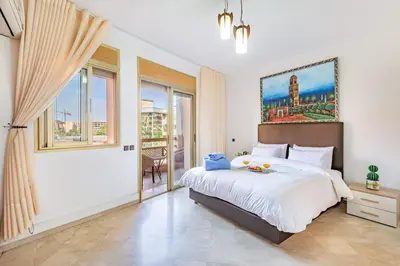 a white bedroom with a large bed and windows at Wintering I Authentic Accommodation I Pool in Marrakech