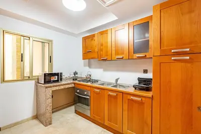 a kitchen with wooden cabinets and a sink at Wintering I Authentic Accommodation I Pool in Marrakech
