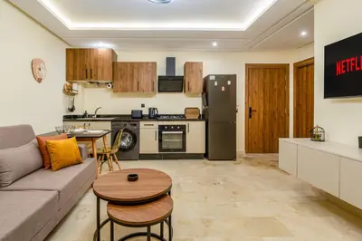 a living room with a couch and a kitchen at Atlas Dream Studio pool & parking included in Marrakech