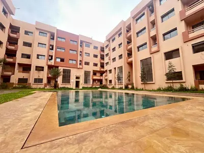 an apartment complex with a swimming pool in front of a building at Atlas Dream Studio pool & parking included in Marrakech