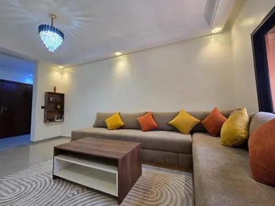 a living room with a couch with colorful pillows at Appartement de luxe, Marrakech Menara in Marrakech