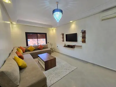 a living room with a couch and a tv at Appartement de luxe, Marrakech Menara in Marrakech